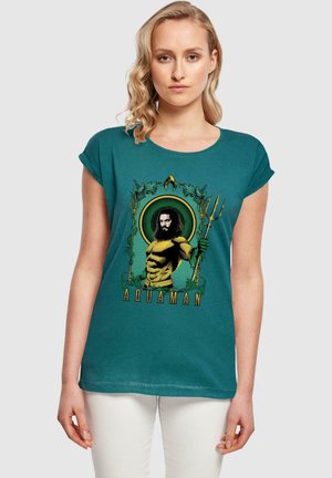 Türkiser T-Shirt mit kurzen Ärmeln, das eine Illustration von Aquaman zeigt, umgeben von grüner Vegetation und mit einem Dreizack in der Hand, mit dem Text "AQUAMAN".