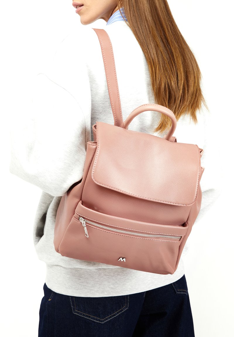 Rožinė odinė kuprinė su dangčiu, priekinė zip kišenė ir viršutinis rankenėlė. Yra reguliuojamos petnešos ir lygus paviršius.