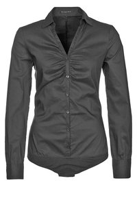 Blouse noire à manches longues ajustée, avec col et détails de tissu froncé au centre avant.