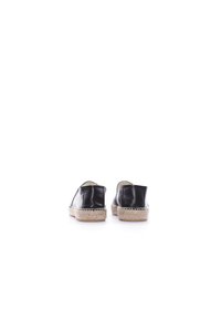Espadrilles de cuero negro con suela de yute trenzada, que presentan un acabado suave y un diseño sin cierres. Se muestran desde la vista trasera.
