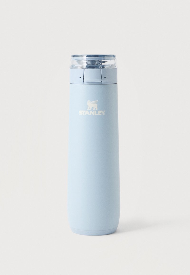 Bouteille de voyage isolante Stanley en acier inoxydable bleu clair avec bouchon rabattable transparent sur fond blanc.