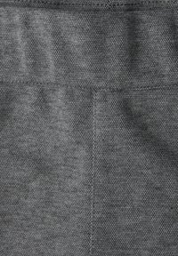 Grauer gewebter Stoff mit einem gewebten Muster, das eine glatte Oberfläche und einen dezenten Glanz aufweist. Keine auffälligen Beschläge oder Akzente vorhanden.