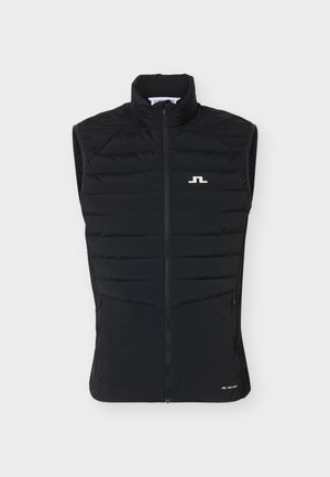 Crna bezrukavka od pročišćenog materijala s visokim ovratnikom, punim prednjim patentnim zatvaračem, dva bočna džepa sa zatvaračima i malim bijelim logotipom na prsištu i donjem rubu.