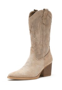 Beżowe zamszowe botki za kostkę z ostrym noskiem, dekoracyjnymi perforacjami oraz słupkowym obcasem. Gładka faktura i akcenty w stylu western.