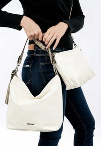 White faux leather shoulder bag with a textured hobo shape, featuring a detachable strap and a small matching zip pouch.