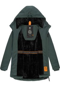 Grön ytterjacka med svart, mjukt innerfoder. Har en orange etikett och dekorerande band över bröstet. Dragkedja fram.