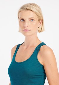 Teal tanktop met brede bandjes en verfijnde schouderdetails. Glad oppervlak en aansluitend ontwerp, wat comfort en bewegingsvrijheid verbetert.