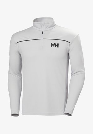 Pulóver blanco de manga larga con media cremallera en el cuello y línea de acento negra; presenta un logo "HH" negro en el lado izquierdo del pecho. Textura de tela suave.