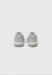 Grå sneakers med en slät överdel i läder och mesh, rund tå, vita detaljer, vadderad krage och en texturerad gummisula.