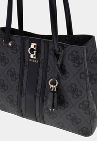 Borsa nera texture con doppie maniglie, dotata di una chiusura a gancetto in tono oro, strisce verticali nere e un pattern distintivo su tutta la superficie.