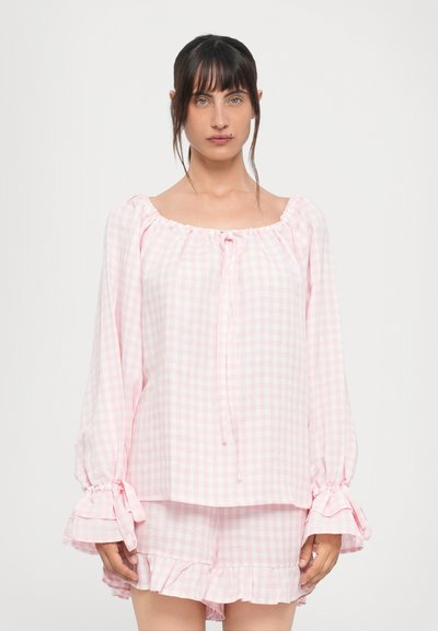 Pink gingham pajama set featuring a ruffled hem, elastic cuffs with ties, and a square neckline. Lightweight fabric for comfort.