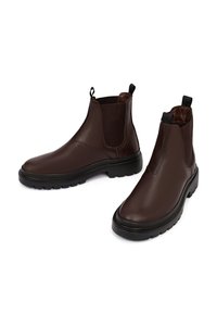 Bruine leren enkellaarsjes met elastische zijkanten, een gladde afwerking en een rubberen zool met een gestructureerd loopvlak voor grip.