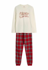 Kremowa bluzka z długim rękawem z grafiką "Stay Cool" w czerwonym kolorze, w połączeniu z czerwonymi spodniami w kratę z białymi i zielonymi paskami. Materiał bawełniany.