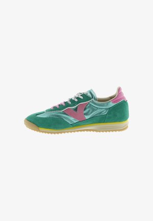 Green and teal athletic shoe with pink accents, white laces, and a yellow-trimmed sole, displayed in a side profile on white background.