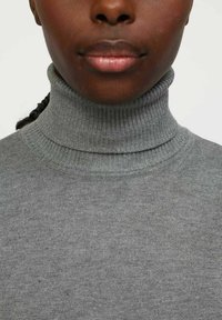 Pilkos spalvos turtleneck megztinis, pagamintas iš smulkios mezgimo medžiagos, su briaunotu tekstūru ir aukštu apykakle, be siūlių.