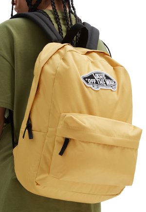 Żółty plecak z tkaniny z czarnymi akcentami i przednią kieszenią. Posiada naszywkę z białym logo Vans. Regulowane czarne paski.