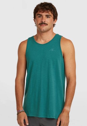 Modrý tank top vyrobený z mäkkého materiálu, s okrúhlym výstrihom a malým logom na hrudi. Ľahký a voľný strih.