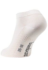 Calza bianca alla caviglia realizzata in materiale morbido e elasticizzato. Caratterizzata da un polsino a coste, un motivo a pois discreto e marcature della taglia stampate sul lato.
