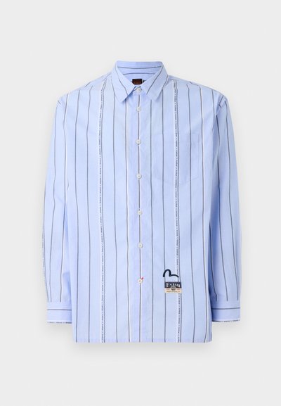 Light blue button-up shirt with vertical white and grey stripes, chest pocket, and logo patch. Made of woven fabric with a smooth texture.