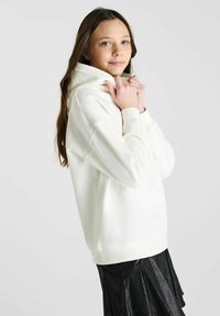 Witte hoodie met een relaxed fit, voorzien van een trekkoordkap en geribbelde manchetten, gecombineerd met een zwarte geplisseerde rok. Soepele textuur.
