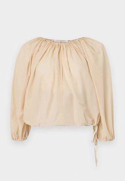 Beige Bluse mit Puffärmel aus leichtem Baumwollstoff. Mit gerafftem Ausschnitt und Kordelzug am Saum für eine verstellbare Passform. Glatte Textur.