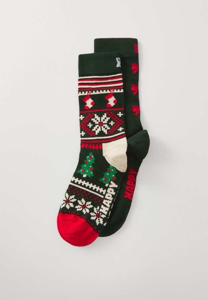 Chaussettes de Noël tricotées avec des couleurs vert foncé, rouge et crème, ornées de motifs d'arbres, de chaussettes et de flocons de neige. Bout rouge et inscription "JOYEUX".