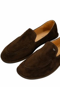 Coppia di mocassini in suede marrone scuro con fodera interna color cuoio e dettagli di cuciture sottili su sfondo bianco.