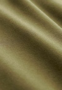 Tessuto verde oliva con una texture liscia, caratterizzato da una leggera elasticità. La vista ravvicinata evidenzia la fine trama e il colore uniforme in tutto il tessuto.