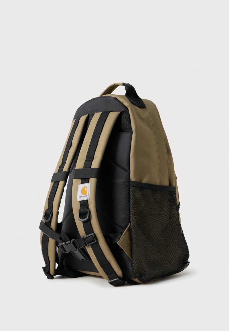 Rückansicht eines olivgrünen und schwarzen Carhartt Rucksacks mit gepolsterten Trägern, verstellbaren Schnallen und einer schwarzen Netztaschen-Seitentasche.