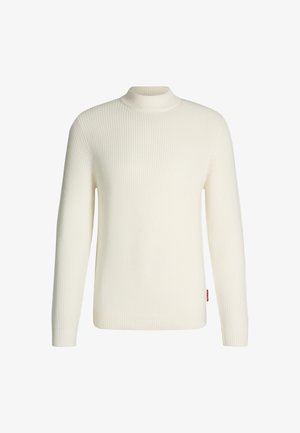 Maglione a collo alto bianco a coste realizzato in tessuto lavorato a maglia; presenta maniche lunghe, un colletto aderente e un'etichetta rossa sul lato.