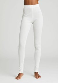 Leggings bianchi aderenti realizzati in un tessuto testurizzato e traspirante. Vita alta e design a lunghezza intera, che mettono in risalto un aspetto liscio e senza cuciture.