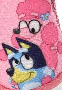 Tejido rosa con personajes de dibujos animados: un poodle rosa con gafas y un perro azul con un acento amarillo y negro. Acabado texturizado y colores vibrantes.