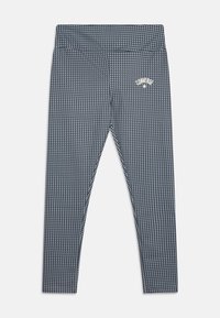 Grå tights med et hundetannmønster, elastisk midjebånd og en liten hvit logo øverst til venstre. Glatt tekstur og tettsittende design.