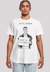 Weißes Baumwoll-T-Shirt mit einem schwarz-weiß Grafik eines Menschen, der ein Schild hält, auf dem "Was meinst du?" steht, mit Text darüber.