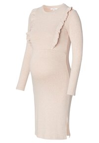 Robe de maternité en doux tissu beige, avec des manches longues, un col rond et un accent volanté à l'avant. Détail de fente sur le côté.