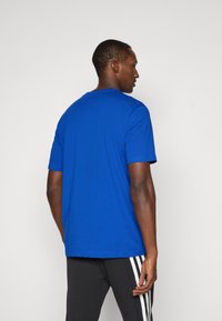 Royal blue, rövid ujjú pamut keverék póló, kerek nyakkal és laza illeszkedéssel. Simább textúra, látható logók vagy minták nélkül.