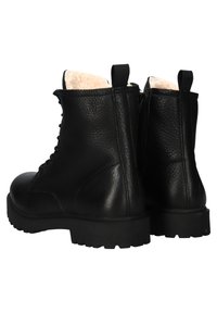 Černé kožené kotníkové boty s šněrováním, silné gumové podešve a krémově zbarvené plyšové podšívky viditelné na horních hranách.