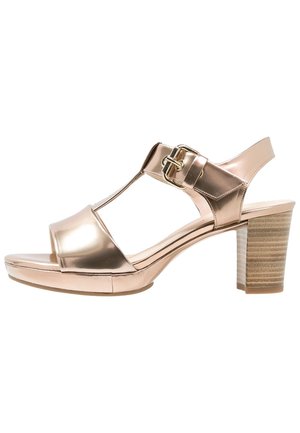 Metallic rosegold højhælet sandal med åben tå, T-strop design, justerbart spænde og struktureret blokhæl. Glat overflade.