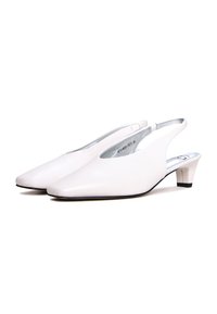 escarpins en cuir blanc à tige ouverte avec un bout pointu, un petit talon et des accents en argent. Texture lisse avec un design minimaliste.