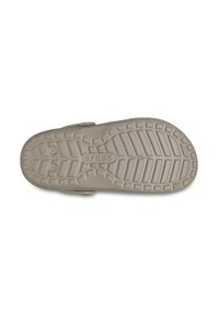 Beige Crocs schoenzool met een gestructureerd oppervlak met verschillende grippatronen en het 'Crocs' logo in het midden afgedrukt.
