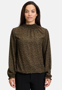 Blusa marrone con stampa leopardata nera, colletto alto arricciato, e maniche lunghe con polsini elasticizzati. Tessuto dalla texture liscia.