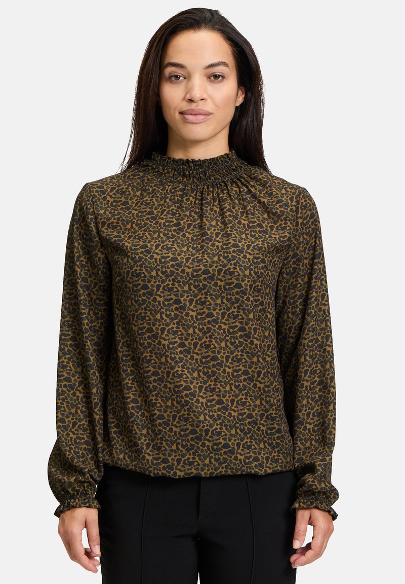 Blusa marrone con stampa leopardata nera, colletto alto arricciato, e maniche lunghe con polsini elasticizzati. Tessuto dalla texture liscia.