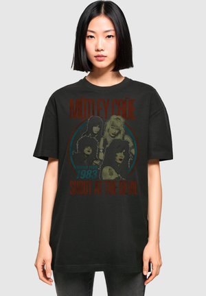 Schwarzes Baumwoll-T-Shirt mit einem frontalen Grafikdruck von vier Bandmitgliedern und dem Text "MÖTLEY CRÜE WORLD TOUR 1983 SHOUT AT THE DEVIL" in Rot.