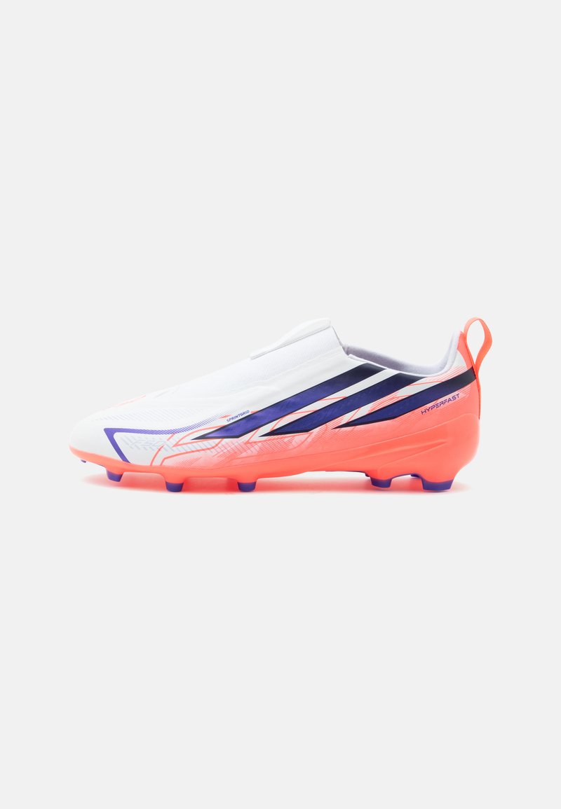 Bota de fútbol blanca y naranja con detalles en morado y rojo, diseño sin cordones y tacos en la suela para tracción.