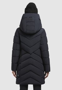 Zwarte pufferjas met een chevron-quiltontwerp, voorzien van een capuchon, lange mouwen en een rechte zoom. Het materiaal lijkt glad en gewatteerd.