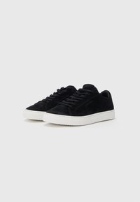 Tenisi negri din suede cu un design de tip low-top, vârf rotund, talpă plată din cauciuc alb și șireturi negre asortate. Stil minimalist, fără modele suplimentare.