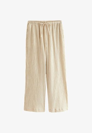 Lysbeige plisserede bukser med elastisk talje og justerbar snøre. Har to sidelommer og et afslappet, bredt ben-design.