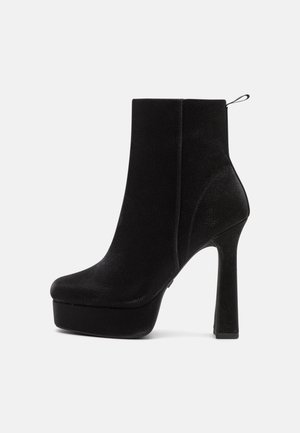 Sort ruskind vintage støvle med platformssål, høj stiletthæl, rund tå og træksløjfe bagpå.