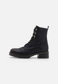 Bottines noires en matériau texturé, dotées de six œillets, d'un bout rond et d'un robuste talon bloc avec une semelle robuste.