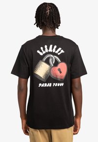 Zwarte katoenen t-shirt met een afbeelding van een hangslot en een hart, met het woord "ELEGANT" erboven en "PARIS 75000" eronder in witte tekst.